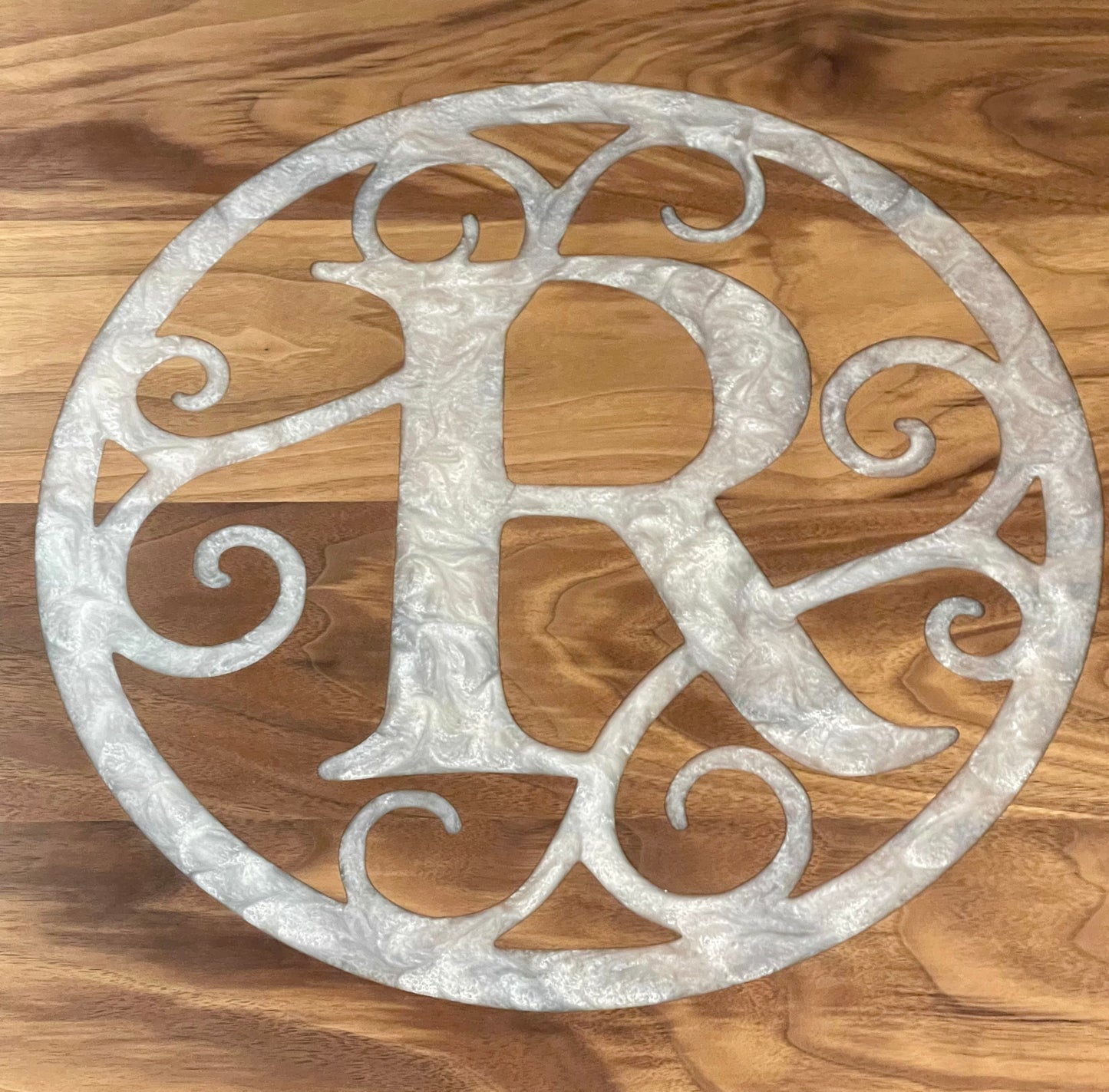Decorative epoxy monogram design on a wooden surface
